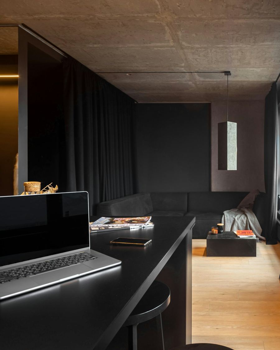 A laptop on a desk in a dark, quiet apartment
